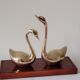 Duo of brass swans on base