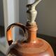 Ancient stoneware jug with a pewter spout.