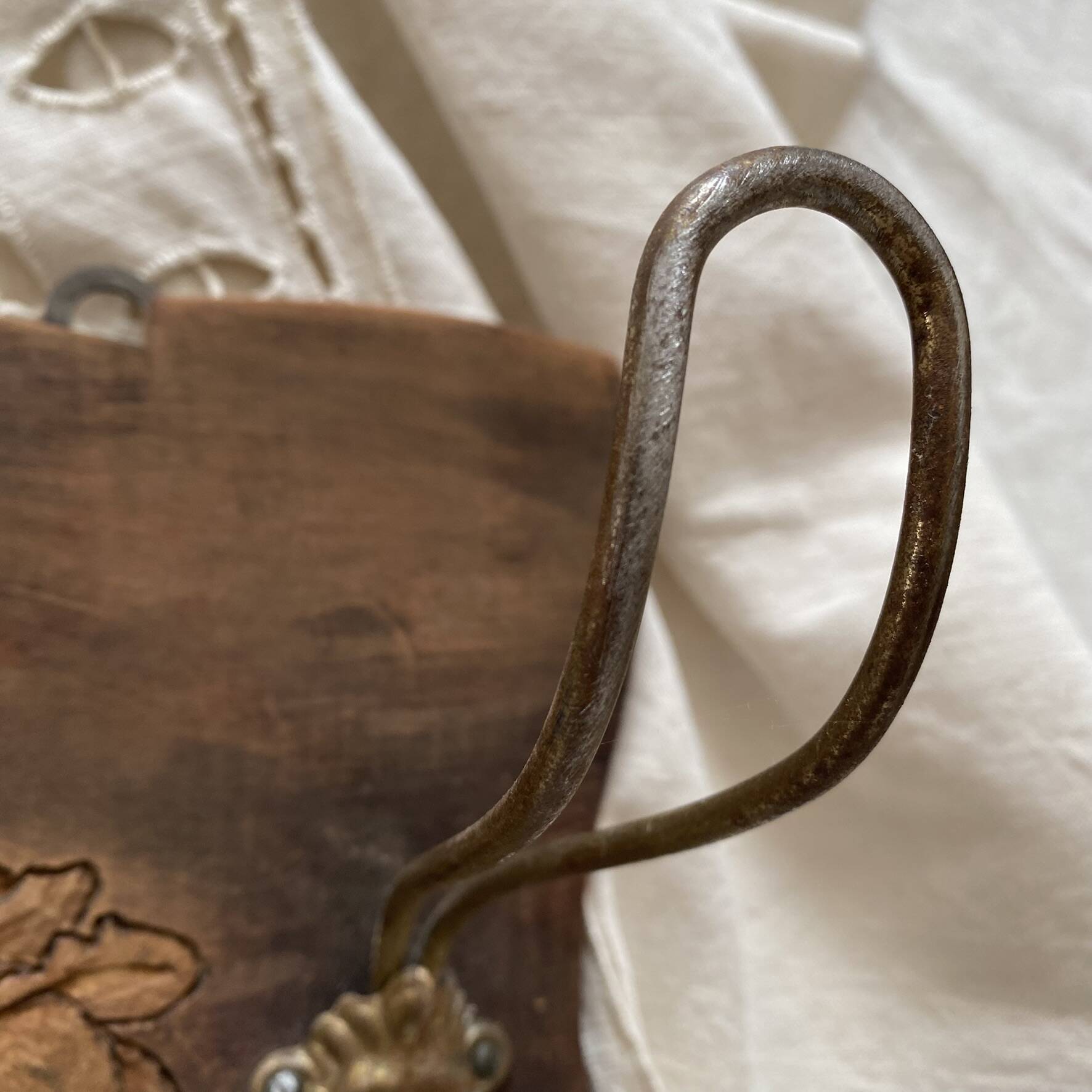 Wall-mounted coat rack in carved wood with rose decoration.