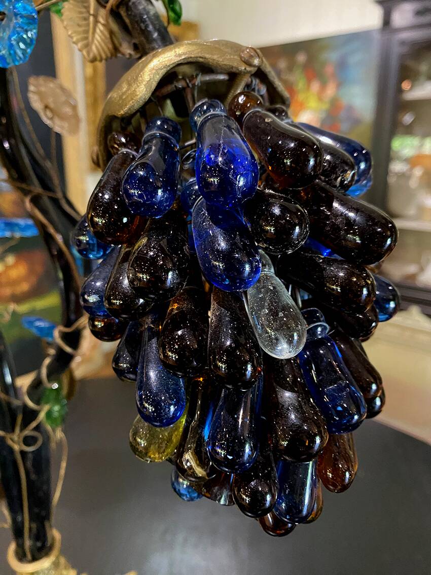 Table lamp with four light arms and globes shaped like bunches of grapes.