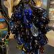 Table lamp with four light arms and globes shaped like bunches of grapes.