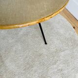 Tripod coffee table with a straw covering.