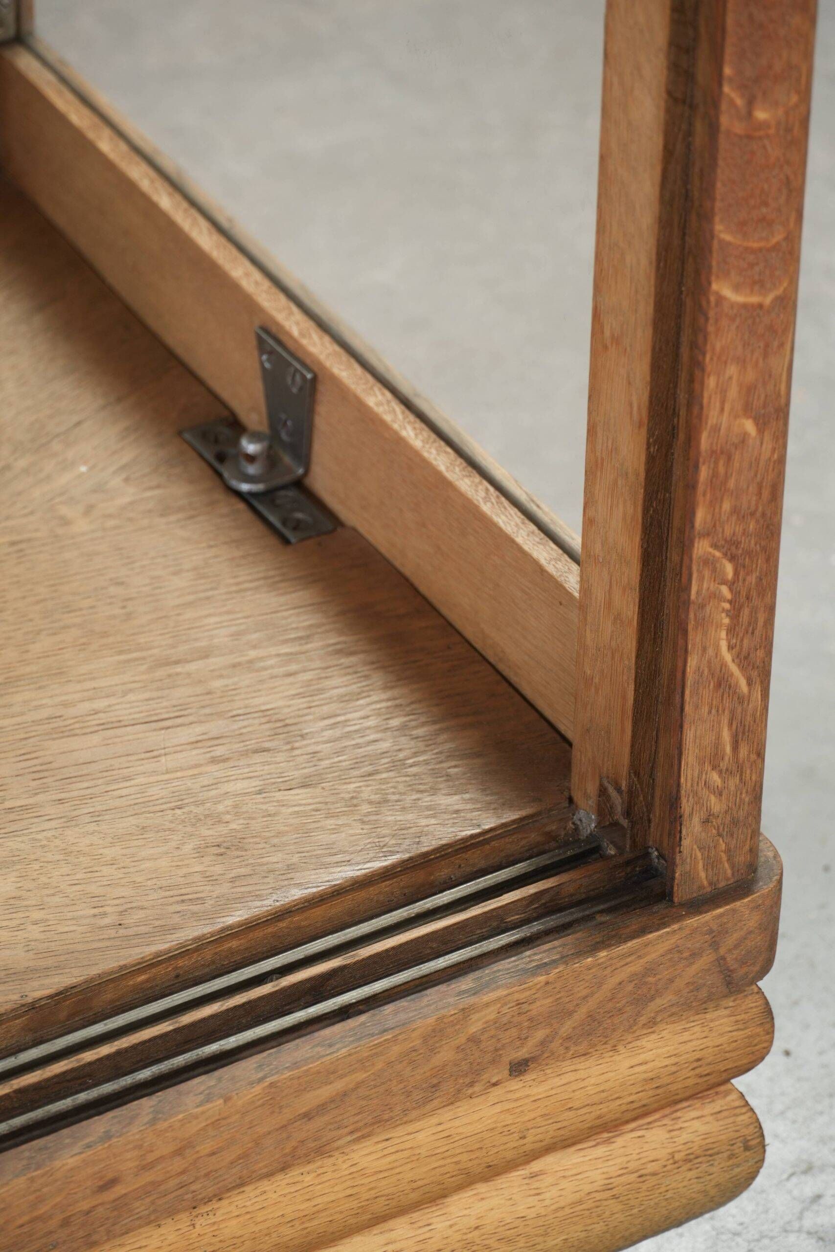 Antique Dutch oak display cabinet with glass shelves and a mirrored back
