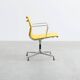 Fauteuil Aluminum Group EA107 de Charles et Ray Eames en tissu jaune.