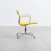 Fauteuil Aluminum Group EA107 de Charles et Ray Eames en tissu jaune.