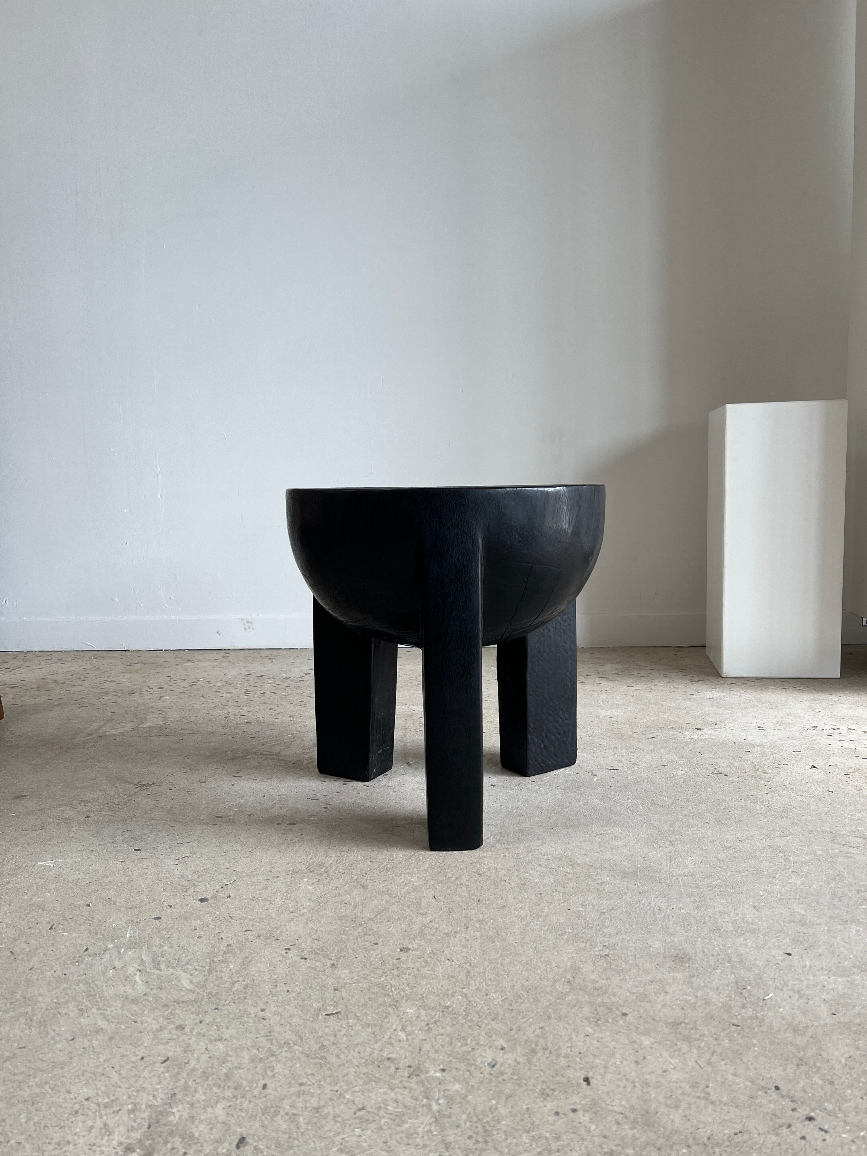Black mango wood tripod side table with a semi-spherical top, height: 45 cm, diameter: 44 cm.