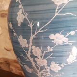 Large blue porcelain lamp with white flowers (cherry blossoms) on wooden stand.