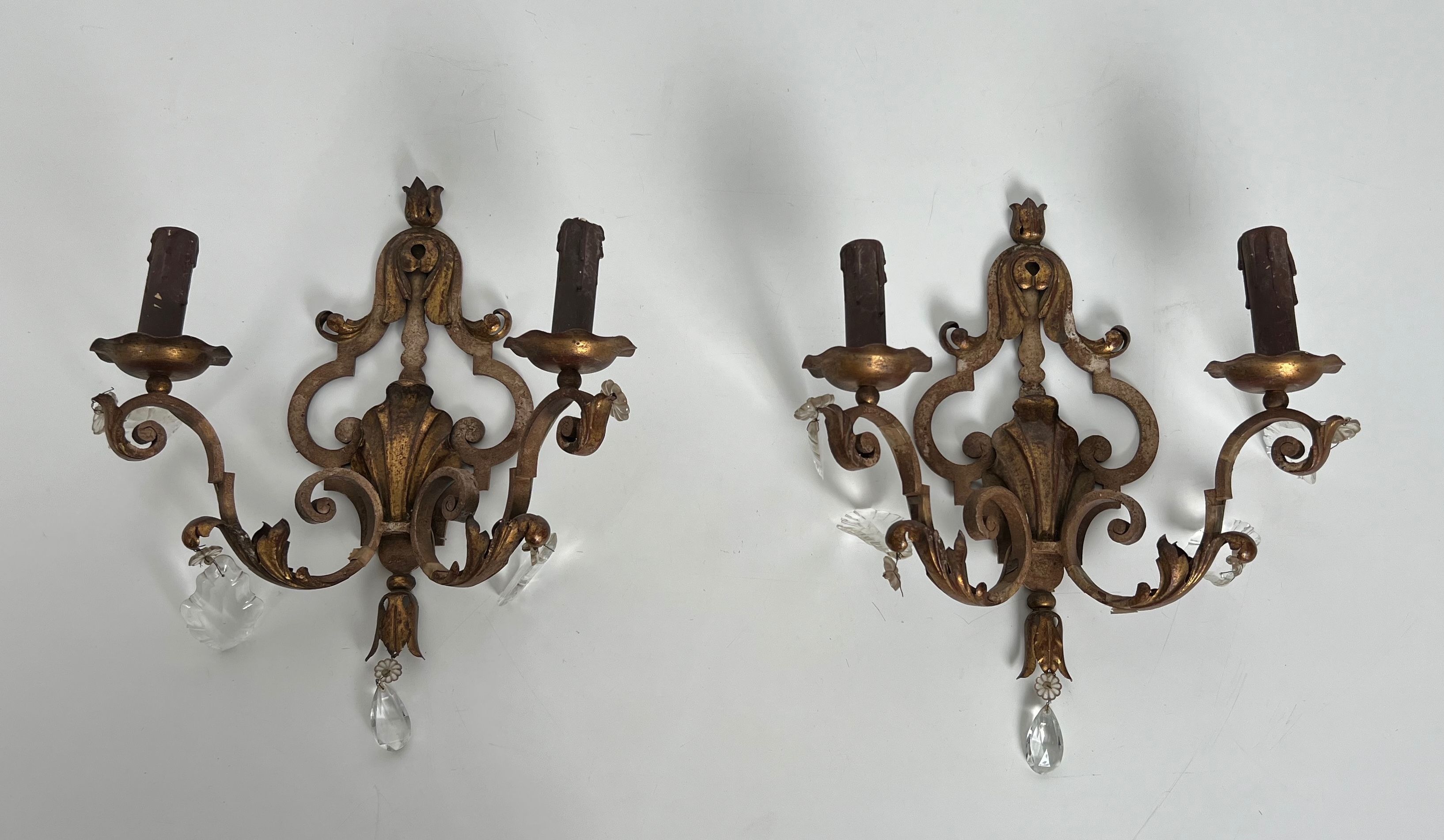 Pair of patinated wrought iron wall sconces with golden acanthus leaves and crystals.