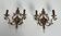Pair of patinated wrought iron wall sconces with golden acanthus leaves and crystals.