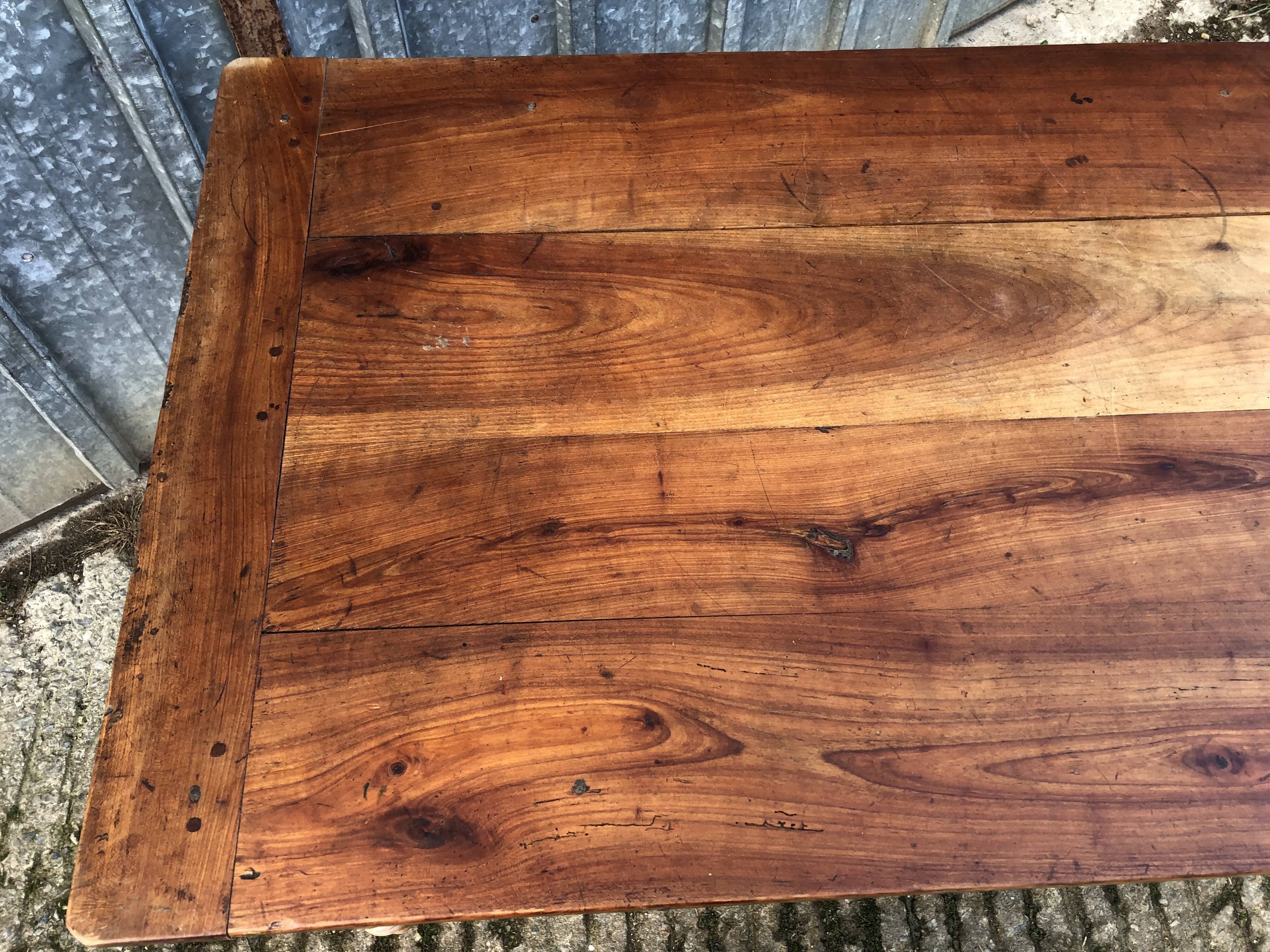 Antique farmhouse table in solid cherry wood with turned legs.