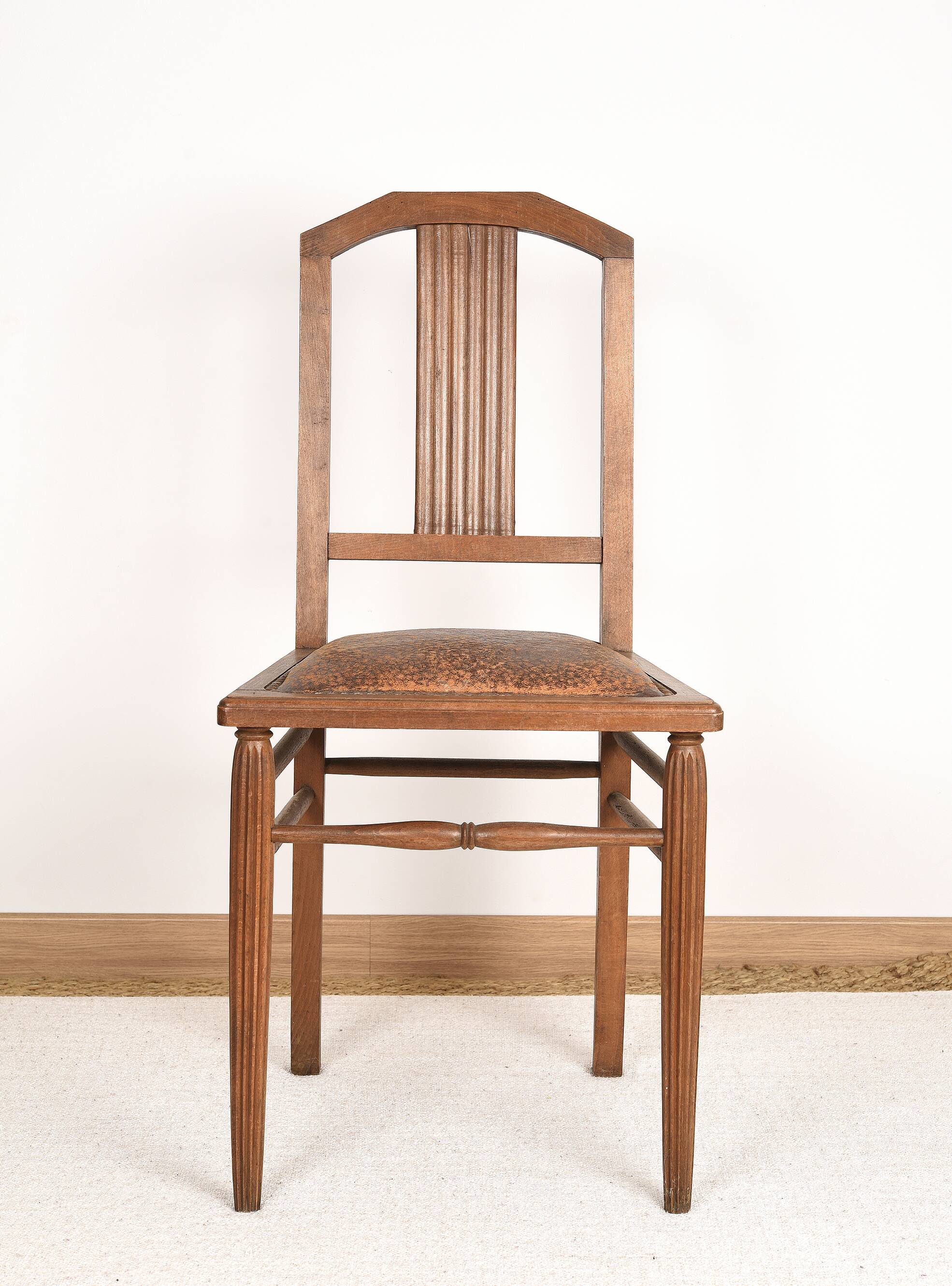 Art Deco style chair in carved wood and leather.