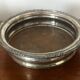 Antique silver-plated bottle coaster with floral decoration.