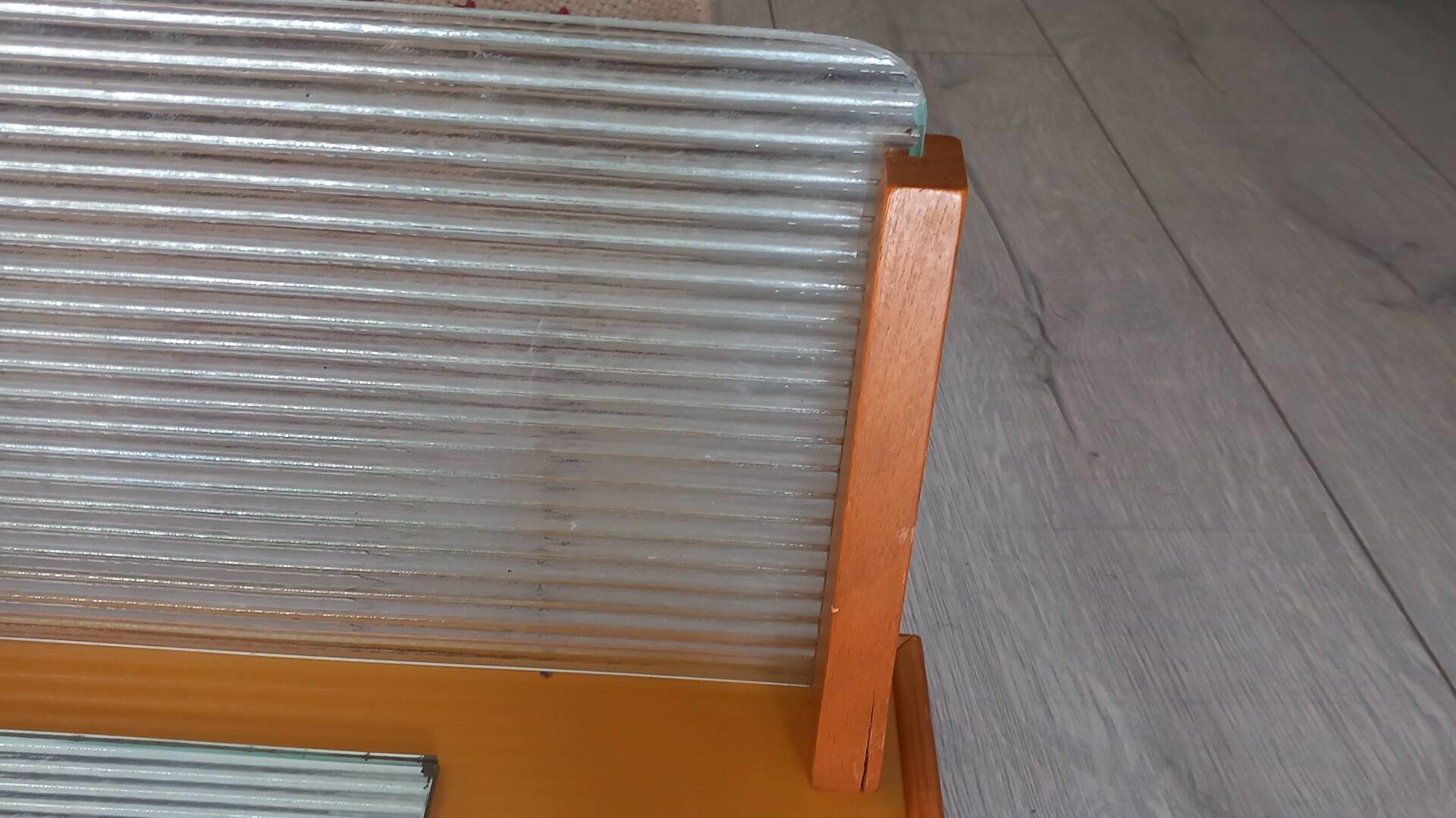 1950s coat rack with mirror, metal hooks, and glass shelf.