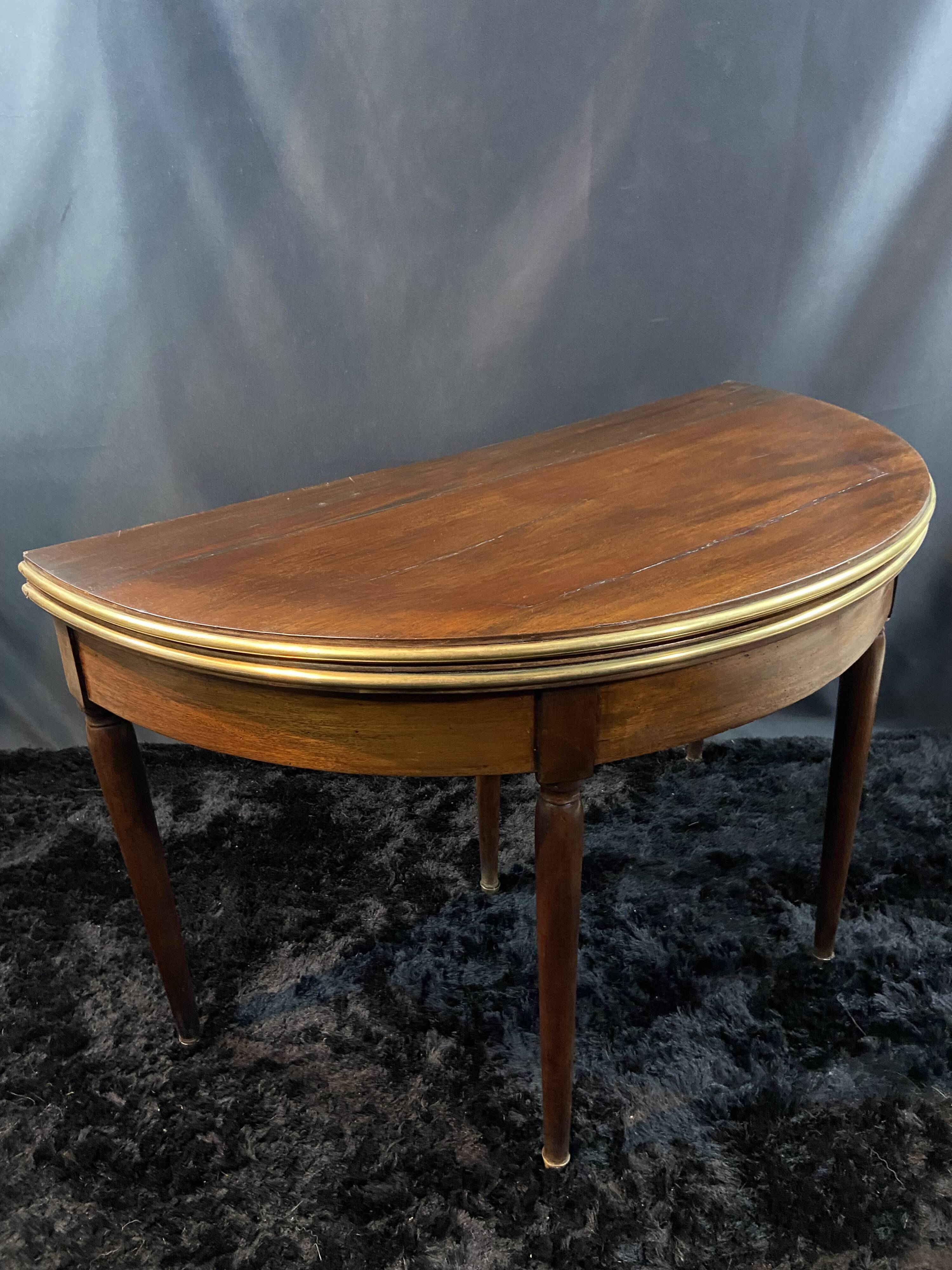 A Louis XVI period mahogany half-moon table forming a console/games table