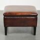 Large dark brown square ottoman made of sheepskin with black piping