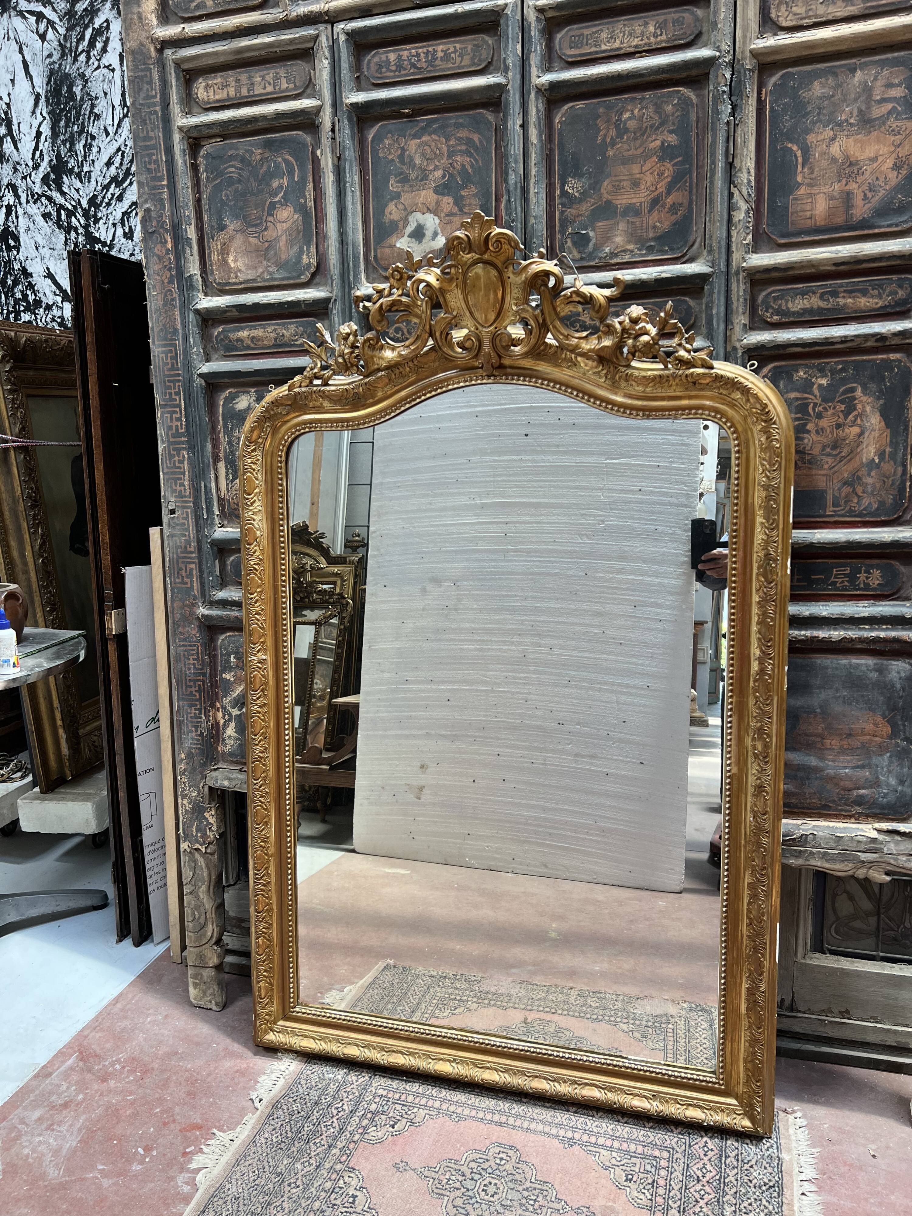 Louis XV style mirror in gilded wood and stucco, 20th century.