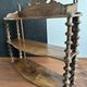 Antique wall shelf made of turned wood and spools of thread, late 19th century.