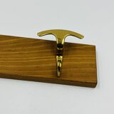 Vintage wall coat rack in brass and wood design.