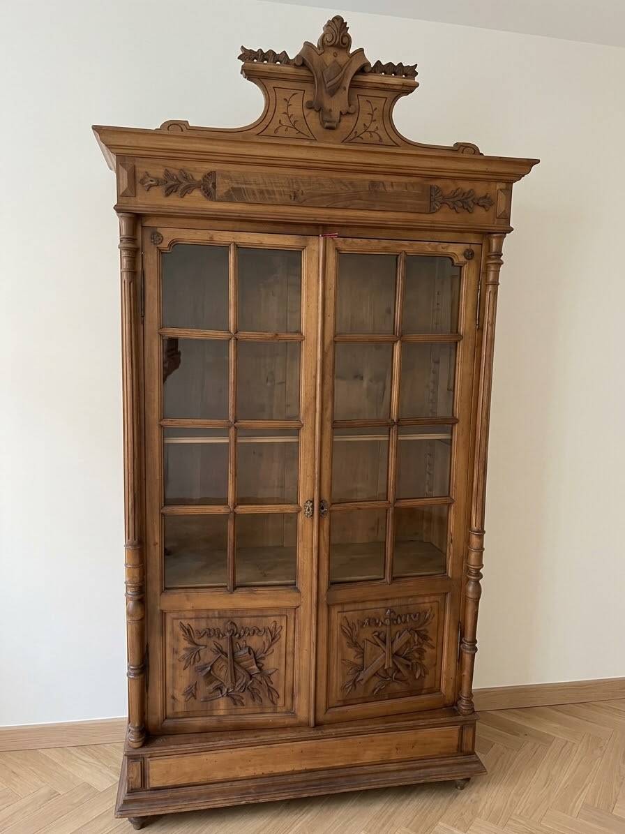 Antique wooden library with a carved pediment.