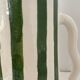 Handmade green and white striped ceramic vase with abstract corrugated handheld