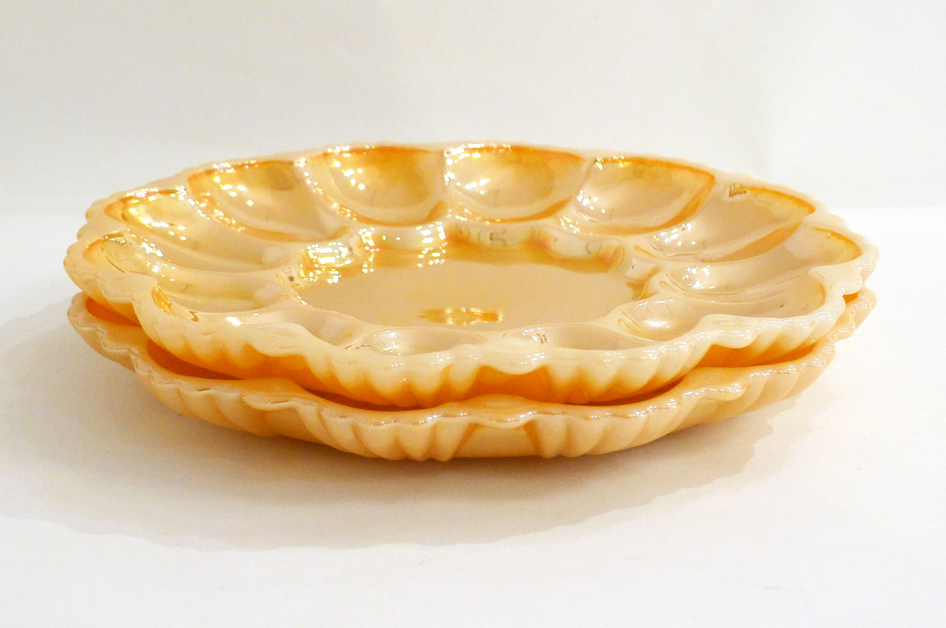 Pair of iridescent orange glass egg plates