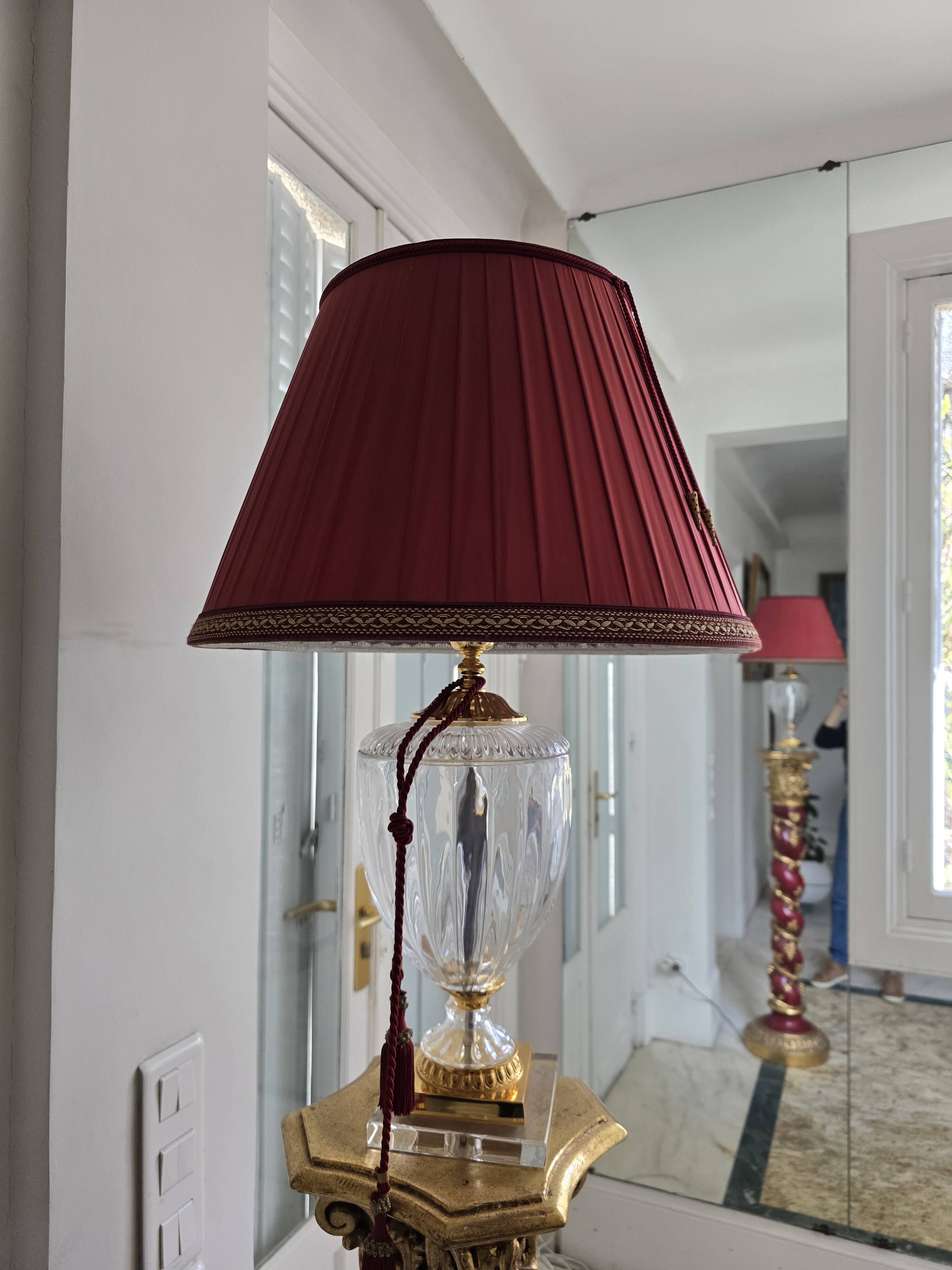 red and gold wooden column in the shape of a vine foot topped with a lamp