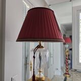 red and gold wooden column in the shape of a vine foot topped with a lamp