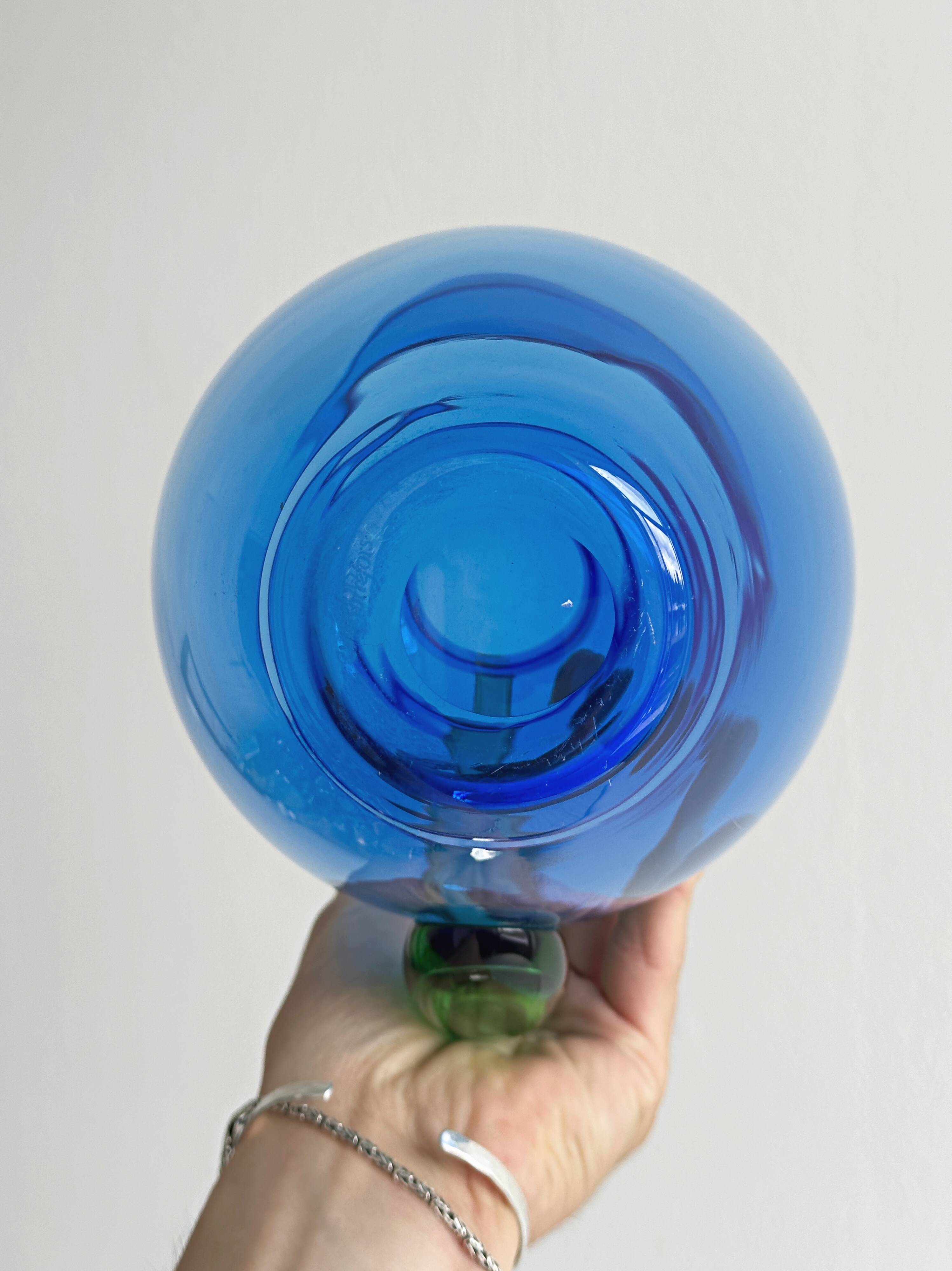 Translucent blue glass jug with a green handle.