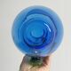 Translucent blue glass jug with a green handle.
