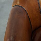 Unique vintage cognac-coloured leather club armchair with black piping