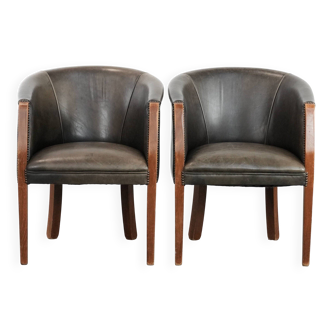 Set of two cowhide and wooden tub chairs with a sturdy colour scheme