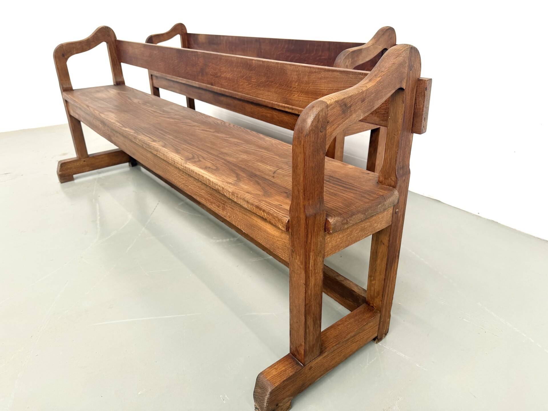 Pair of communal benches in solid oak, 1950s.