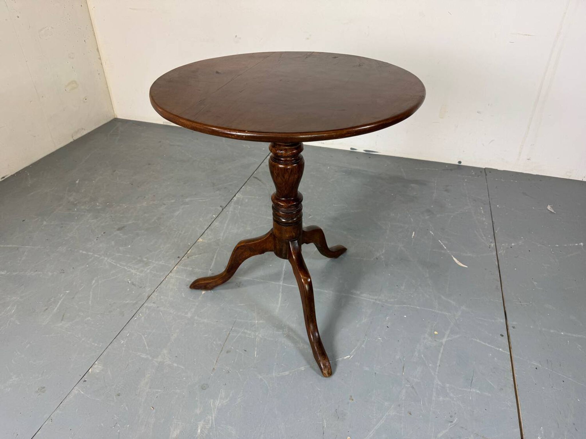 Round coffee table with an adjustable top in antique mahogany.