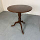 Table basse ronde à plateau inclinable en acajou ancien.