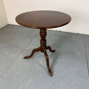 Round coffee table with an adjustable top in antique mahogany.