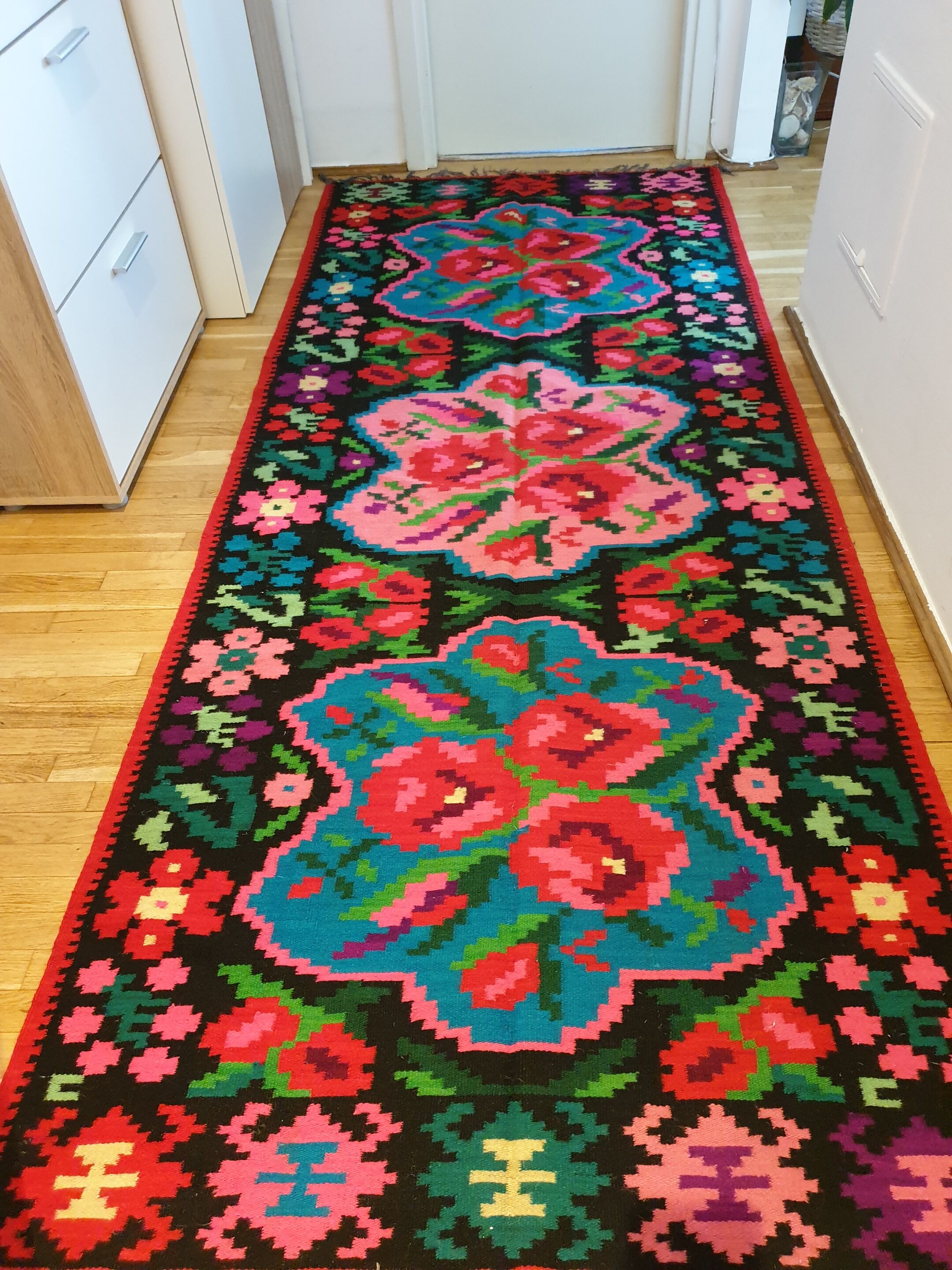 Colorful kilim on black background with floral design