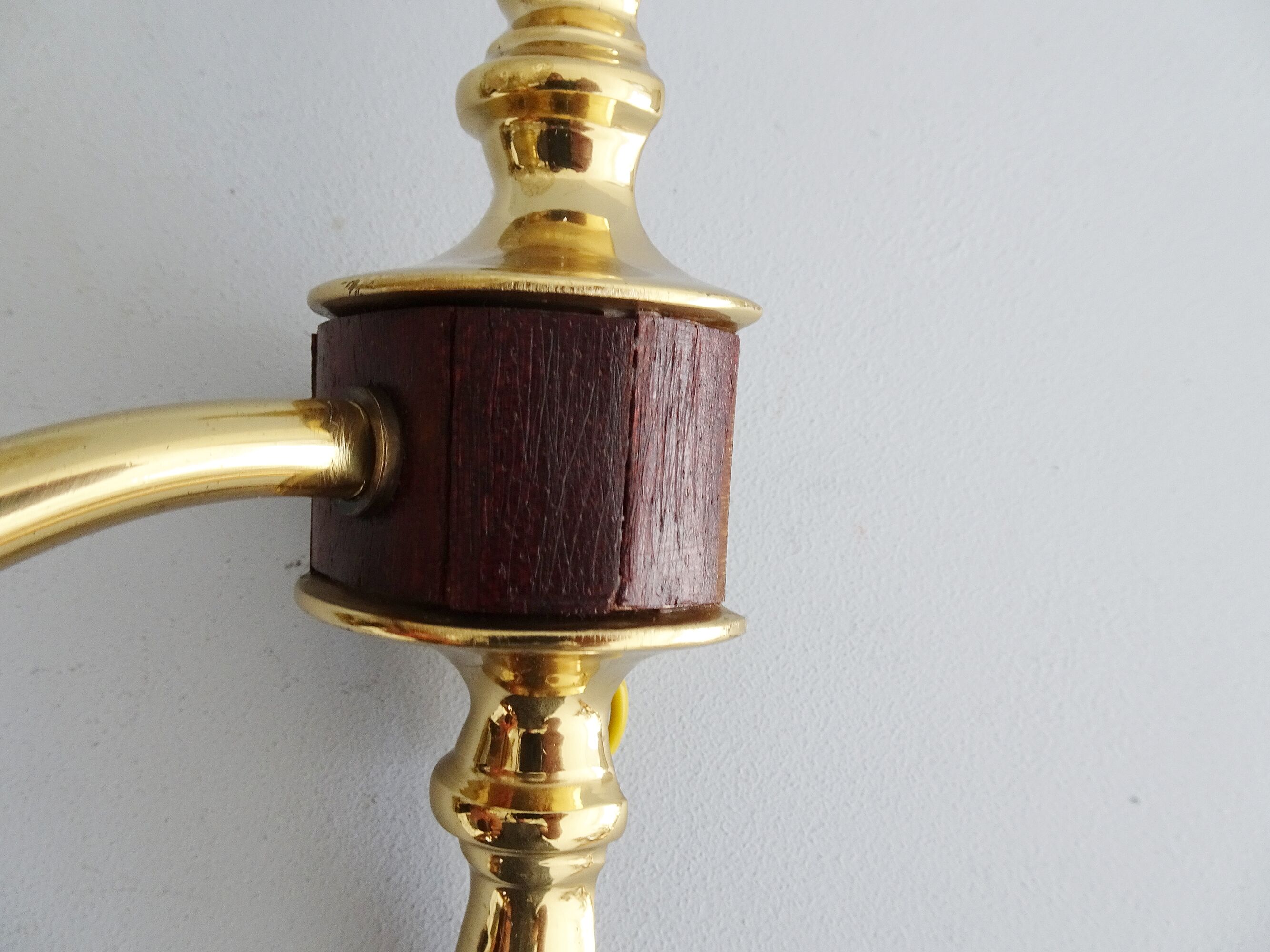 Golden wall lamps with round glass shades and teak veneer