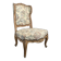 Louis XV style armchair in natural wood with floral fabric.