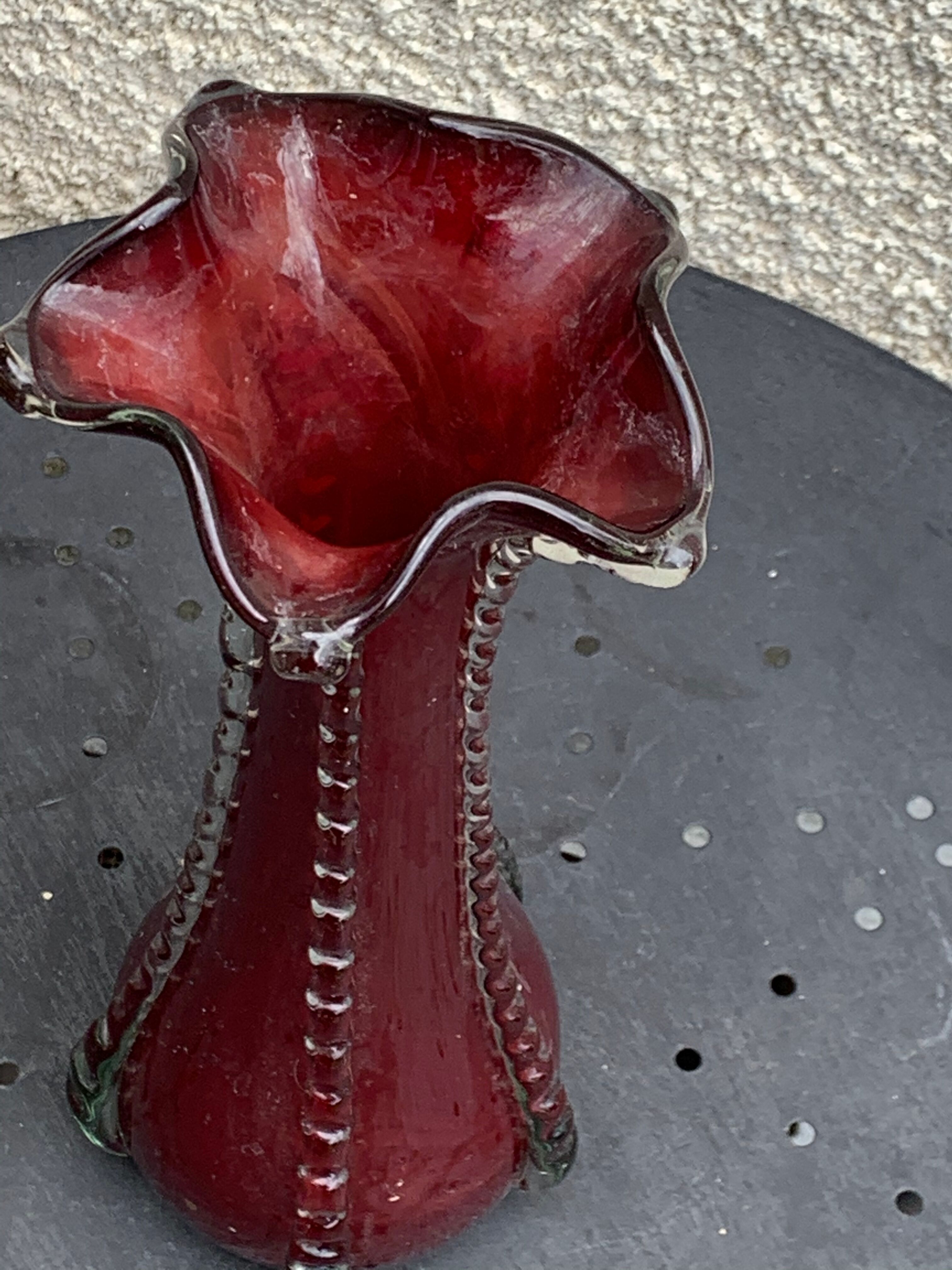 Burgundy red blown glass vase in the shape of a vintage corolla
