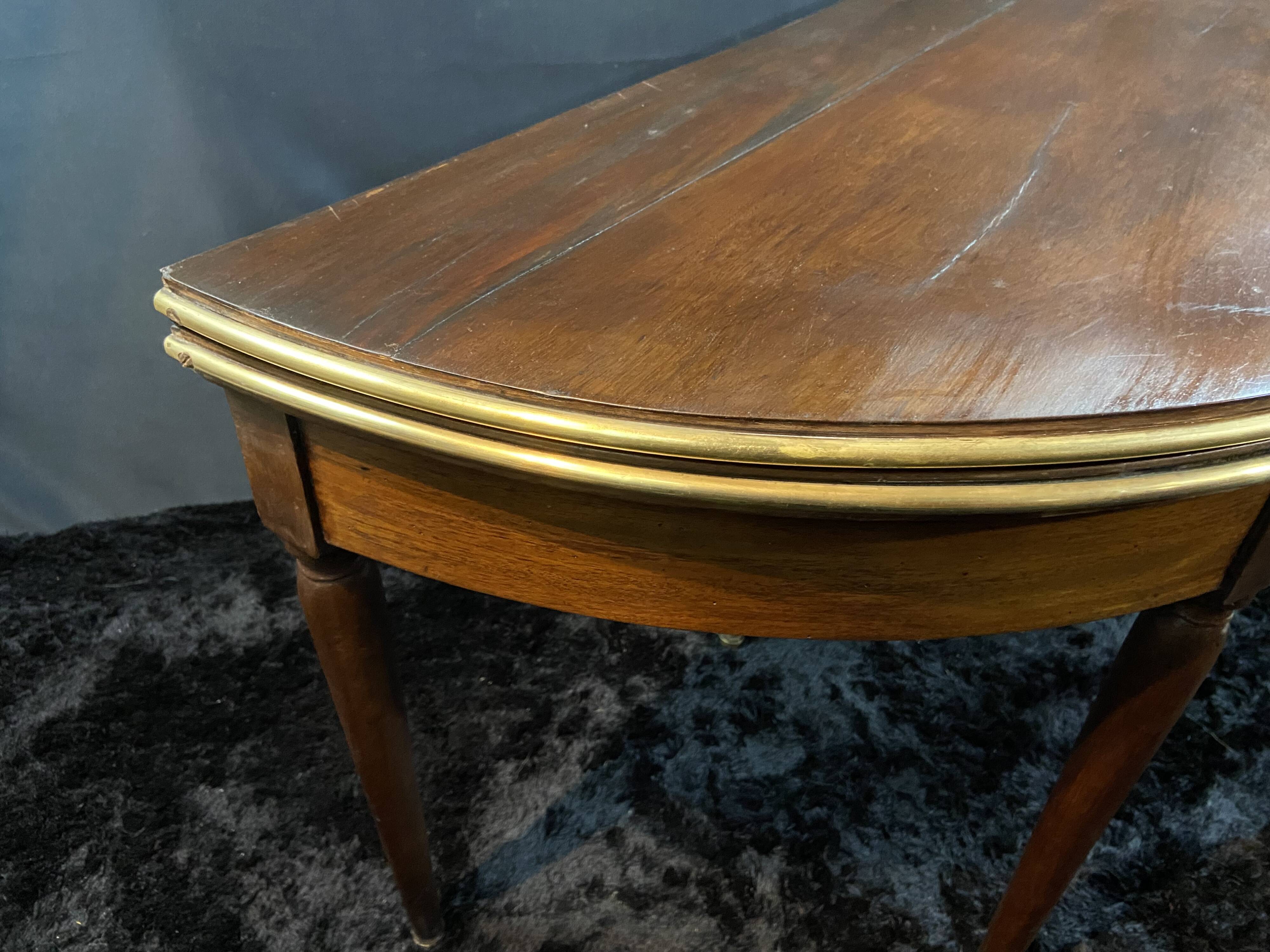 A Louis XVI period mahogany half-moon table forming a console/games table