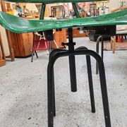 Vintage swivel workshop chair in green pressed sheet metal with a folding backrest.