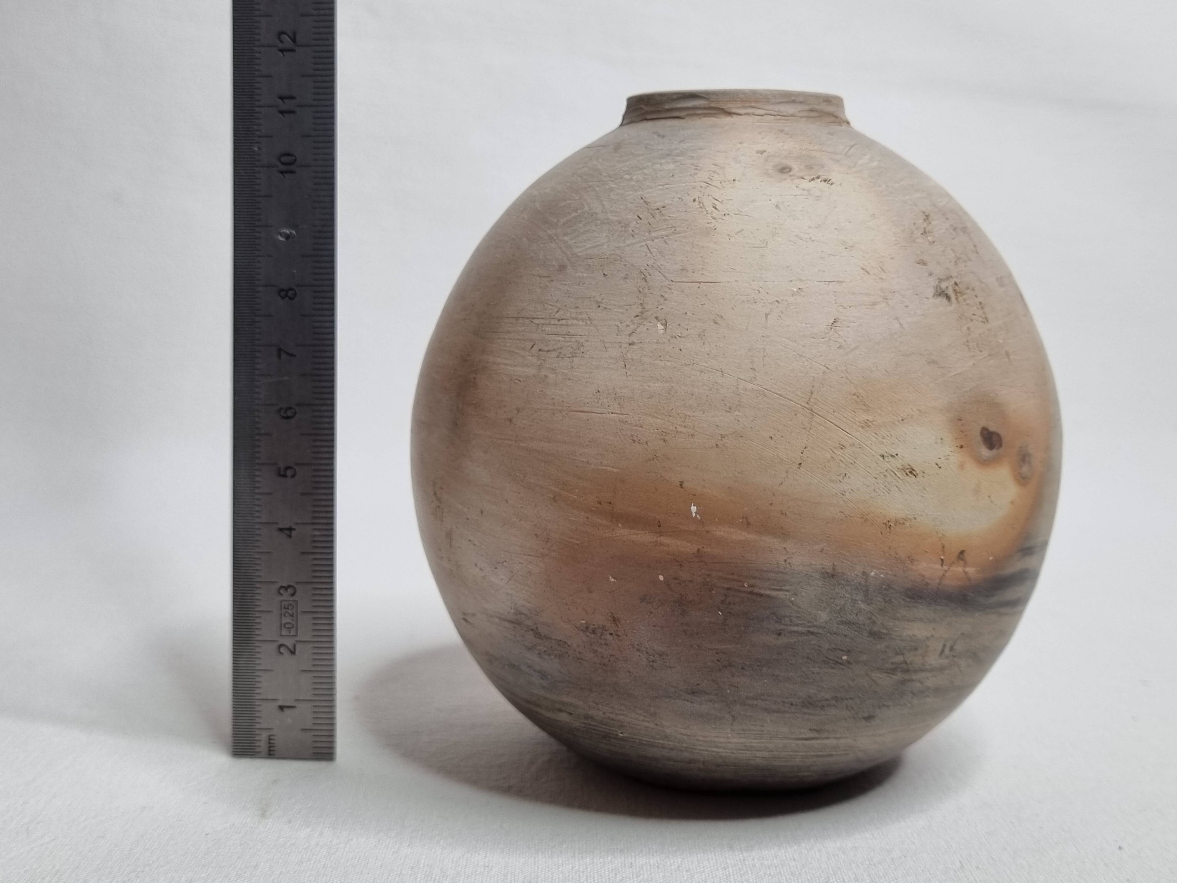 Round ceramic vase with raw finish, smoked firing, signed, late 20th century, 11 cm.