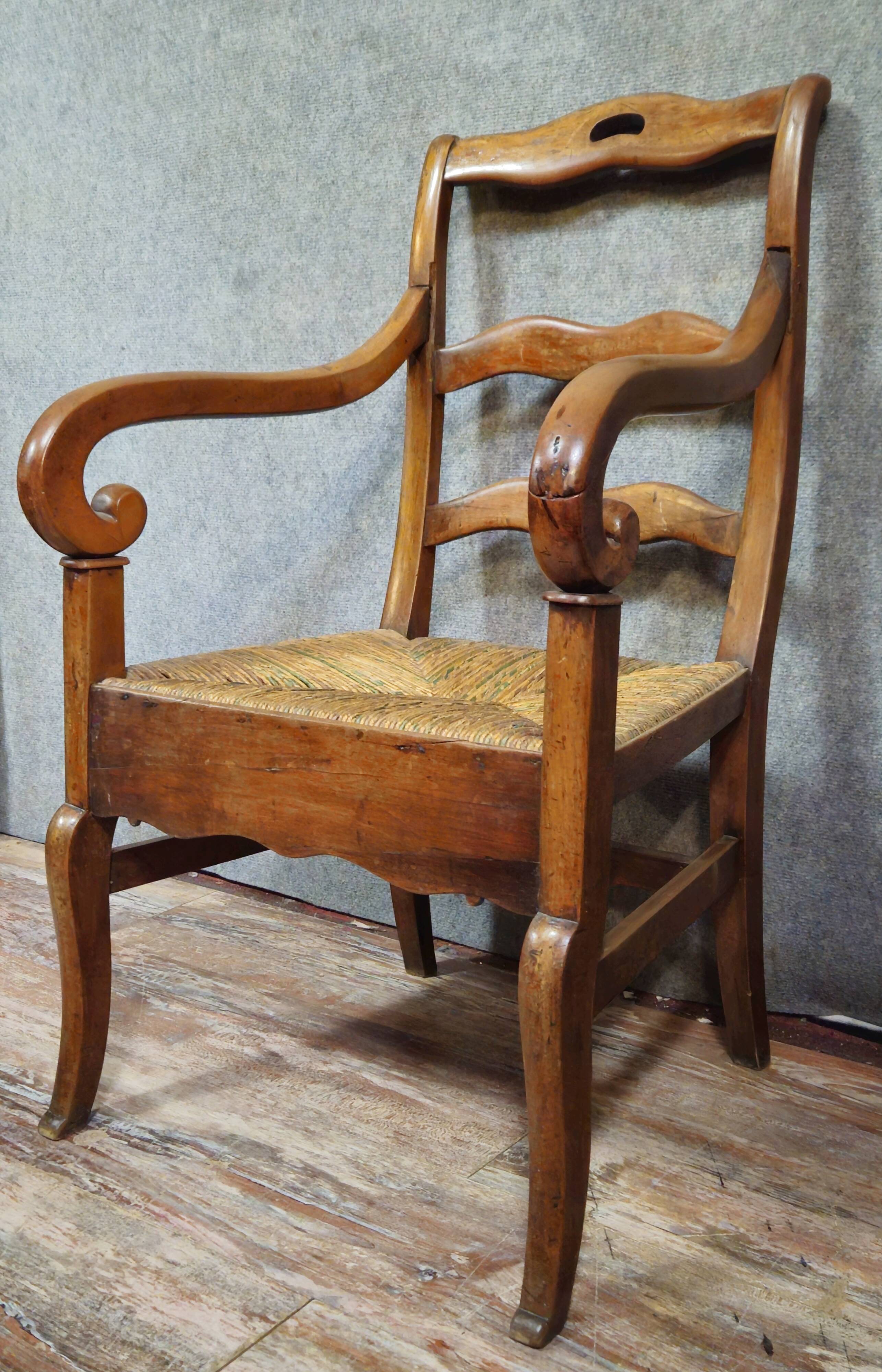 Empire armchair in solid walnut with woven straw seat.