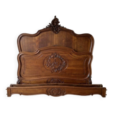 Antique carved bed in Louis XV style made of wood.