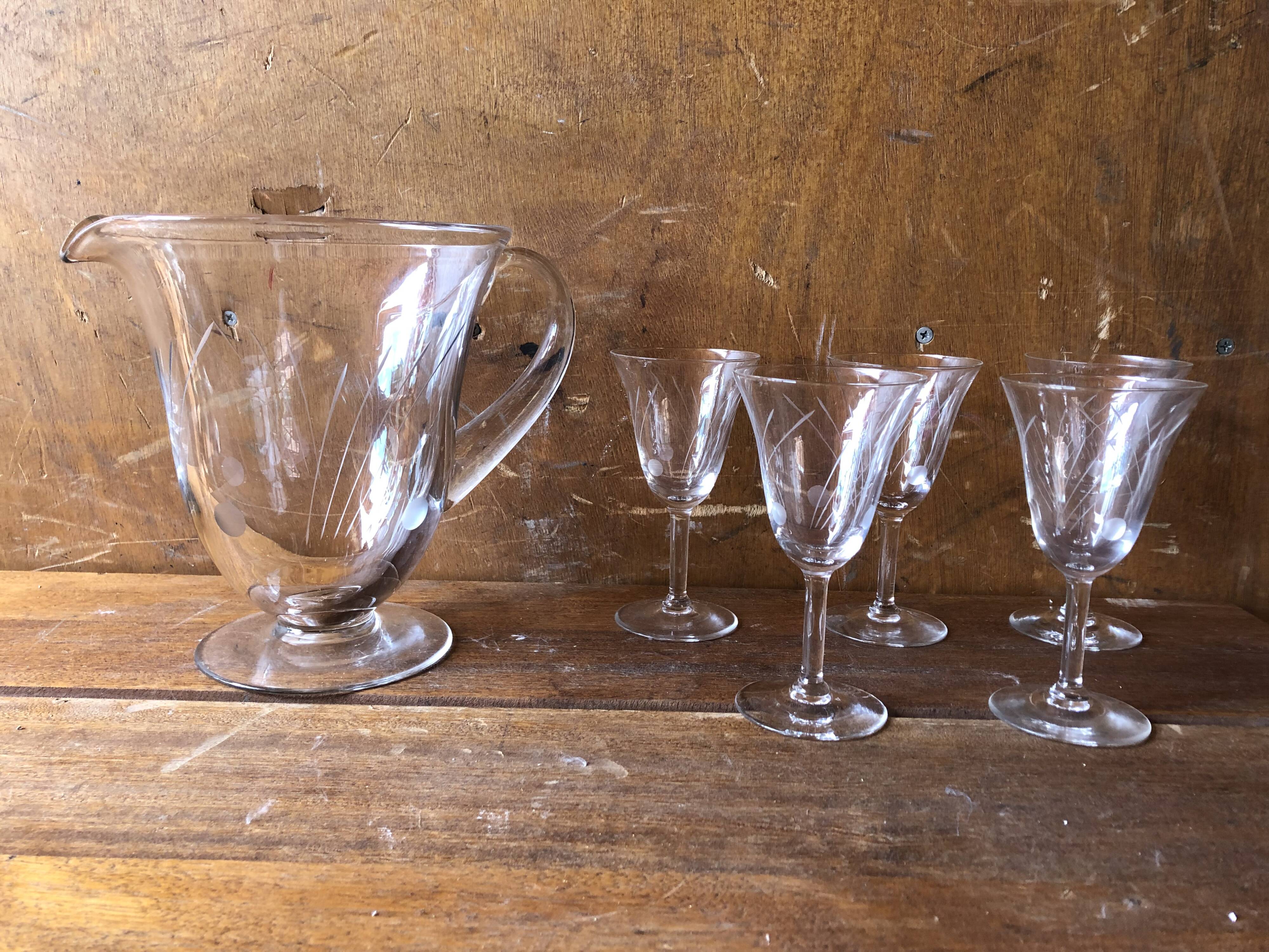 Old pitcher service and 5 foot glasses in engraved glass vintage table art