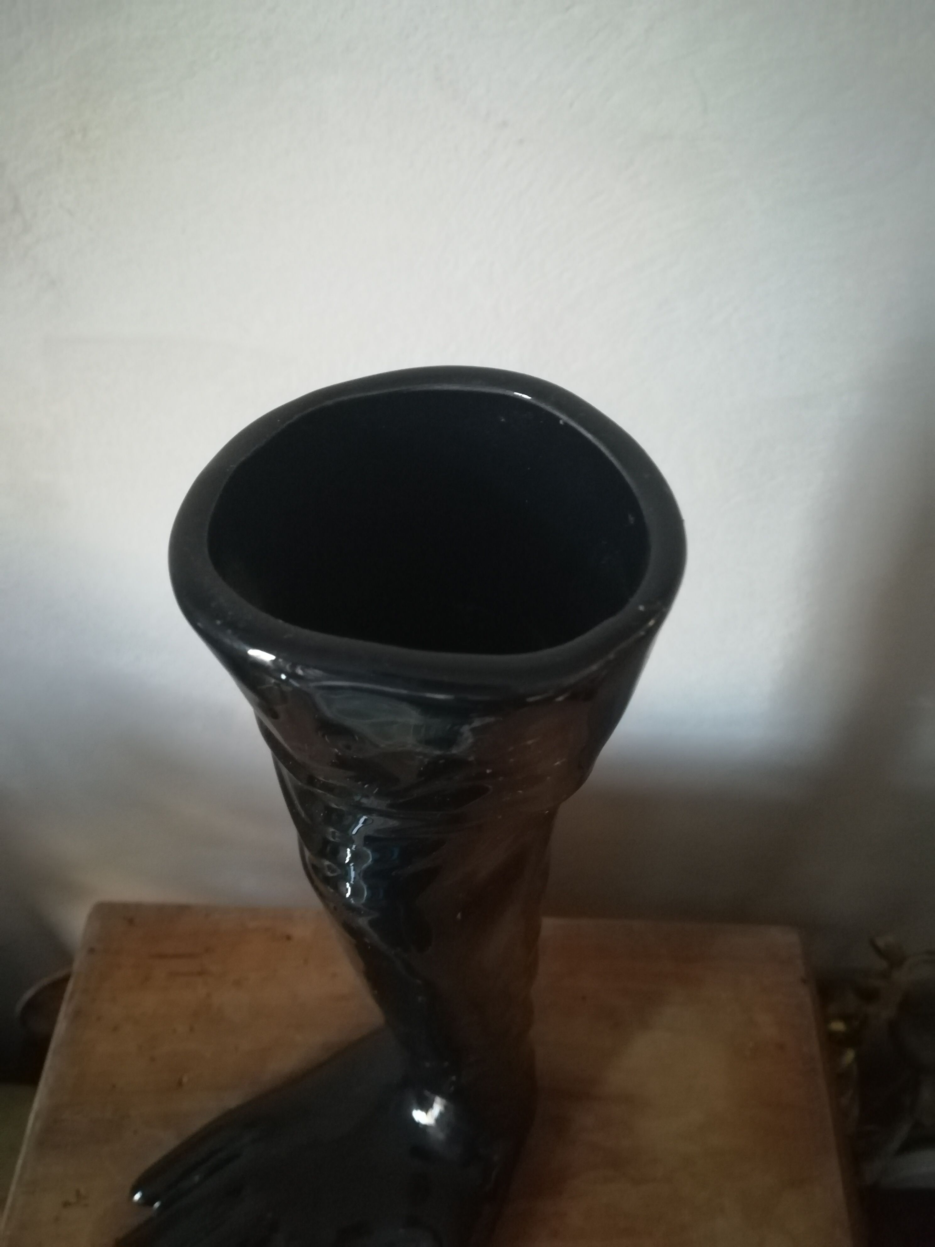 Black earthenware vase gloved hand
