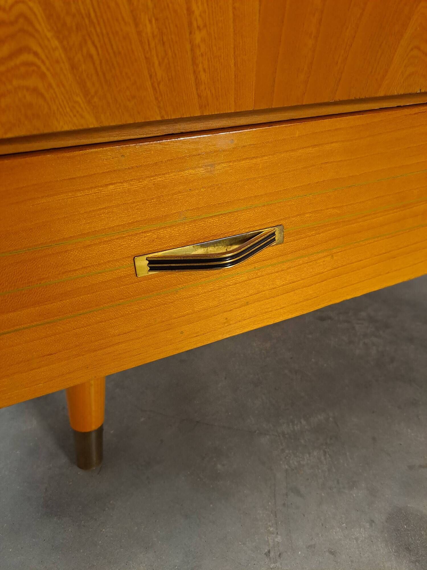 Meuble TV audio avec poignées en laiton et pieds inclinés.