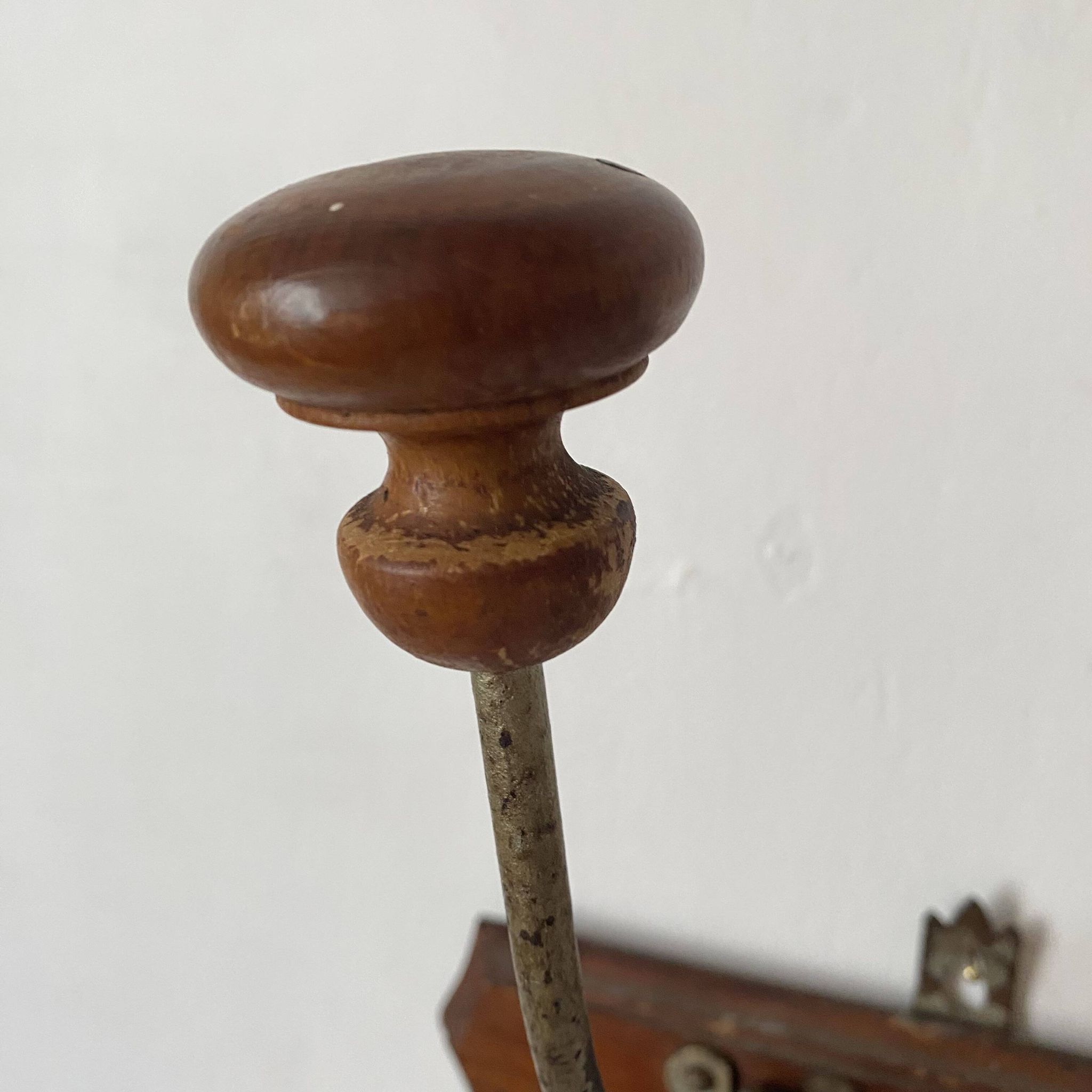 Old wooden and metal wall-mounted coat rack.