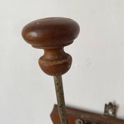 Old wooden and metal wall-mounted coat rack.