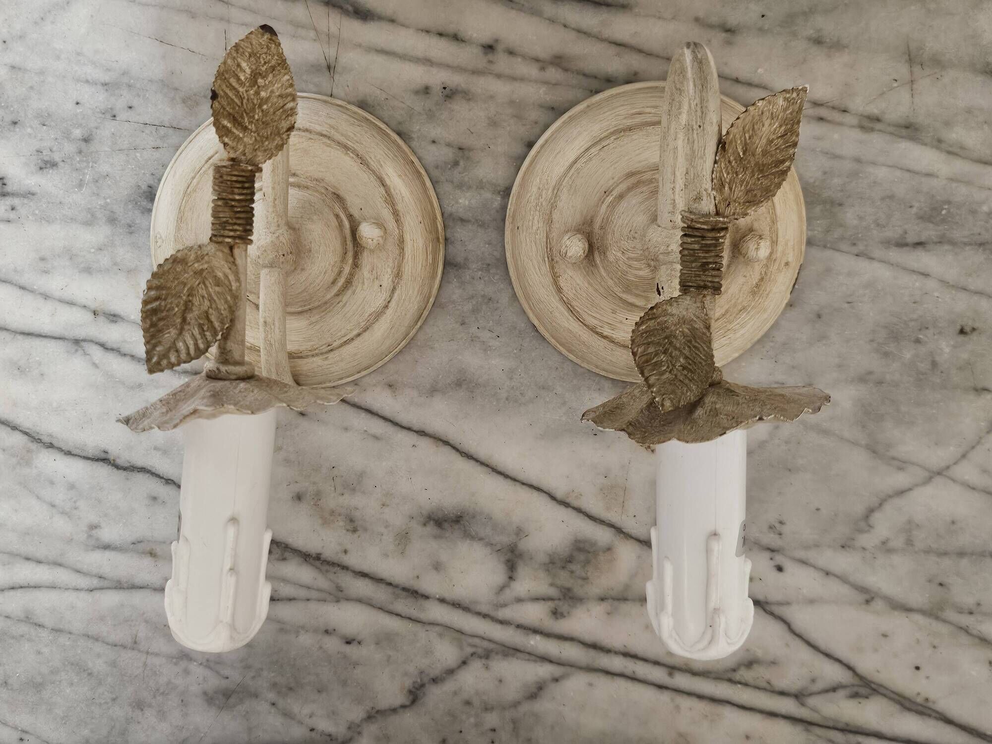 Pair of cream patinated metal wall sconces with floral decoration.